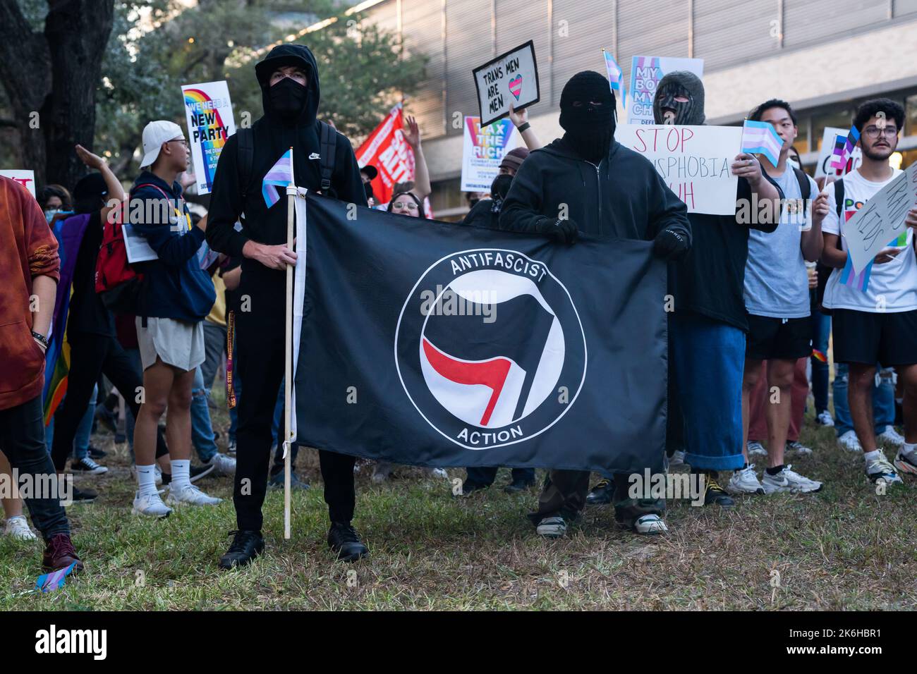 Antifa in black bloc hold an 'Antifascist Action' flag outside a screening of Matt Walsh`s documentary What Is A Woman at the University of Houston Stock Photo